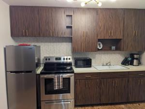 a kitchen with wooden cabinets and a stainless steel refrigerator at Mid Century Style Cottage Near Historic Downtown in Eustis