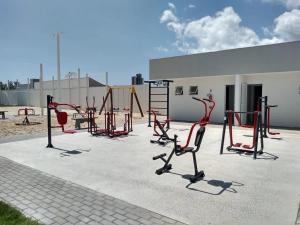 plac zabaw z czerwonym sprzętem przed budynkiem w obiekcie Residencial Angelus Condomínio Clube na Praia de Piçarras w mieście Balneário Piçarras