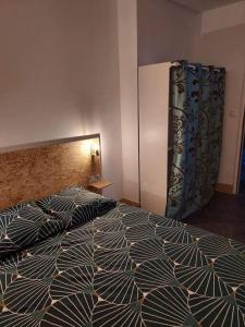 1 dormitorio con 1 cama y nevera en Petite maison de campagne en Castillon-de-Castets