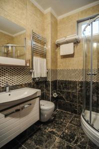y baño con aseo, lavabo y ducha. en Doa Apartment, en Trabzon