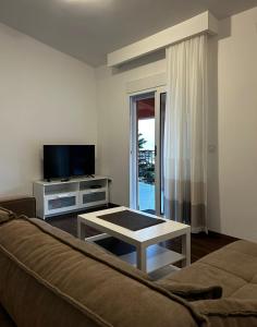 a living room with a couch and a tv and a table at Apartments Sergej in Sutomore