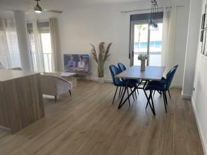 a dining room and living room with a table and chairs at Clauadris Home ideal para familias in Águilas