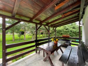a wooden pergola with a wooden table and benches at Vila Alunis 2 in Bran