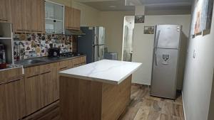 a kitchen with a stainless steel refrigerator and wooden cabinets at DONDE MI MADRE in Montenegro