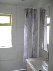 a bathroom with a shower curtain and a sink at Central Reykjavík Apartment in Reykjavík