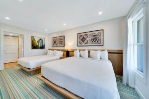 um quarto de hotel com duas camas e uma janela em Mahalo Cape May em Cape May