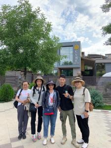 un grupo de personas de pie en frente de un edificio en Cube House Osh, en Osh