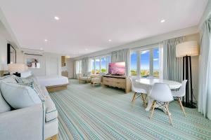 五月岬郡Mahalo Cape May的一间带床、桌椅的酒店房间