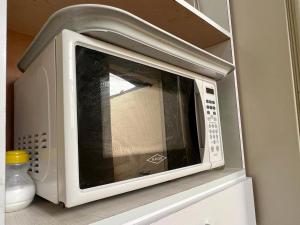 a microwave oven sitting on top of a shelf at La Candelaria in Bogotá