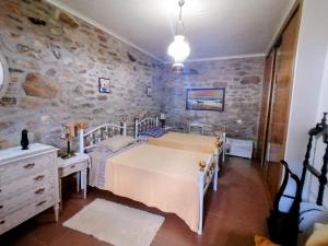 a bedroom with a bed and a stone wall at LÍRIOS DA GRANJA - CASA DE CAMPO in Granja
