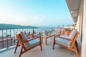 a balcony with chairs and a table and a view of the water at Gizz Suites in Fethiye