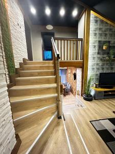 Villa Monte في فيلينغراد: درج خشبي في غرفة معيشة مع أريكة