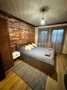 a bedroom with a bed and a brick wall at Villa Monte in Velingrad