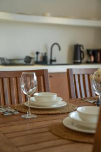 una mesa de madera con platos y copas de vino. en Gizz Suites City, en Fethiye