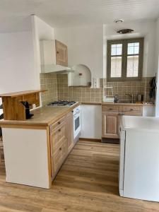 cocina con electrodomésticos blancos y suelo de madera en Le gîte du lavoir, 