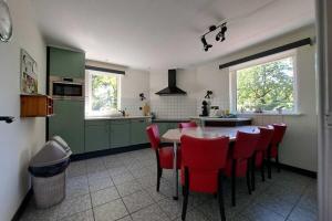 een keuken met een tafel en rode stoelen. bij Pleasant Holiday Home in Haps with garden in Haps