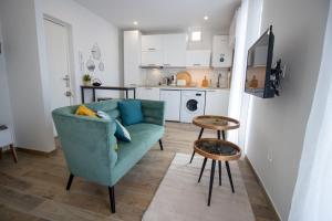 een woonkamer met een groene bank en een keuken bij Élégant Studio Climatisé 'Alma 2' - Cœur de Beziers - Wifi Fibre - Netflix in Béziers +16 foto's