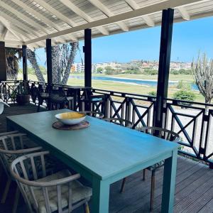 a blue table on a porch with chairs and a bowl on it at Villa at Blue Bay Resort with stunning view in Willemstad