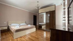 a bedroom with a bed and a large mirror at Cottage in Bakuriani