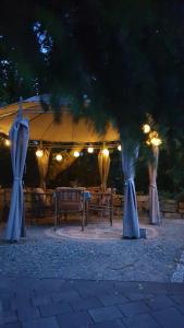 a tent with tables and benches under it at night at Tinyhaus Wolkenlos Familie Hamdorf in Bad Sulza