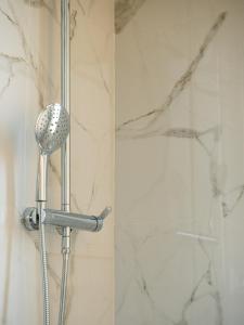 a shower with a shower head in a bathroom at Maestrale Apartment in Cagliari