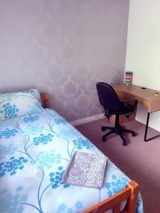 a bedroom with a bed and a desk and a chair at Harvard Road in Manchester