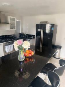 a kitchen with a vase of flowers and a bowl of fruit at Harvard Road in Manchester