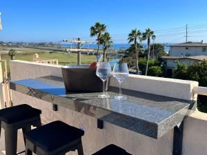 Dos copas de vino sobre una mesa en un balcón. en Water and sunset views in dreamy Cardiff by the sea, en Encinitas
