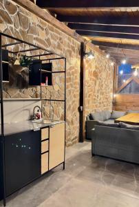cocina y sala de estar con pared de piedra en Villa Monte, en Velingrad