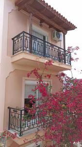 a building with a balcony with pink flowers on it at Bougainvillea Apartment Spacious Family Home in Zakynthos Town in Zakynthos