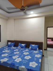 a bedroom with a bed with blue sheets and a ceiling at Hanumant kripa geust house only for family in Ujjain
