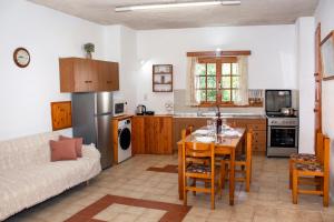 cocina y sala de estar con mesa y sofá en Anastasia Country Home en Strovlés