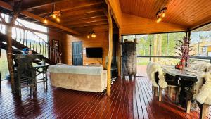 a large living room with a couch and a table at Pousada Cachoeira da Neve- Chalé Quero Quero in Urubici