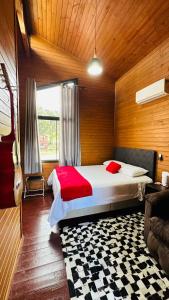 een slaapkamer met een bed in een kamer met een gitaar bij Pousada Cachoeira da Neve- Chalé Quero Quero in Urubici