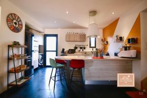 uma cozinha com um balcão e bancos num quarto em Villa Kaz des sables em La Seyne-sur-Mer
