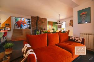 een woonkamer met een oranje bank en een keuken bij Villa Kaz des sables in La Seyne-sur-Mer