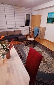 een woonkamer met een bank en een tafel bij Brand New - Central Apartments in Sarajevo