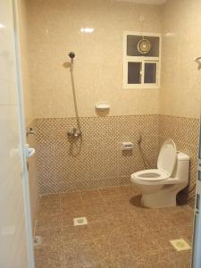 a bathroom with a toilet and a shower at Argaan Apartment in Salalah