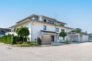 a white house with a driveway at FENJOY Ferienwohnungen am Chiemsee - Zentral - BBQ in Bernau am Chiemsee