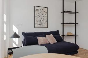 ein Wohnzimmer mit einem blauen Sofa und einem Tisch in der Unterkunft Das Grüne Haus - Boutique Apartments ecofriendly in Innsbruck