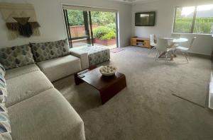 a living room with a couch and a table at Baybell Lodge in Omanawa