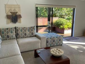 a living room with a couch and a table at Baybell Lodge in Tauranga