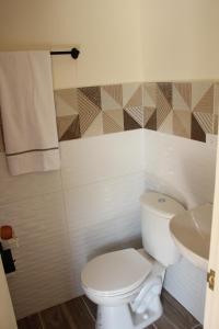 een badkamer met een wit toilet en een wastafel bij Apartaestudio sur de Cali in Cali