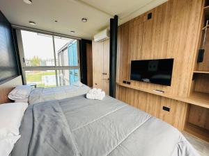 1 dormitorio con 2 camas y TV de pantalla plana en Cubos de Chacras AZUL en Mendoza