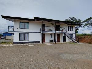 Casa blanca con porche y entrada en Apartamento de una habitación, en San Isidro