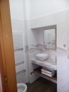 a white bathroom with a sink and a mirror at Bed And Breakfasts LA CASETTA in Terranova di Pollino