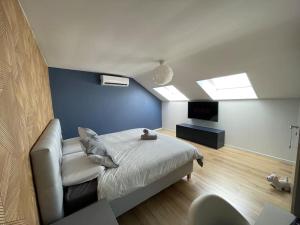 een slaapkamer met een bed en een blauwe muur bij Duplex 100m2 style contemporain in Seraing