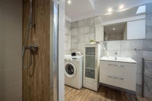 een badkamer met een wasmachine en een wastafel bij Centric Rooftop 4 bedroom apartment in Łódź