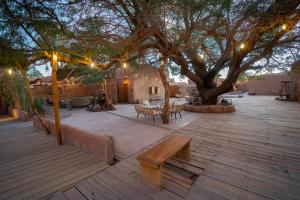 eine Terrasse mit einem Baum, Bänken und Lichtern in der Unterkunft Hotel Don Raul in San Pedro de Atacama