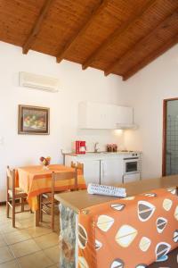 a kitchen with a table and a kitchen with white cabinets at Kotronas Bay Bungalows in Kotronas